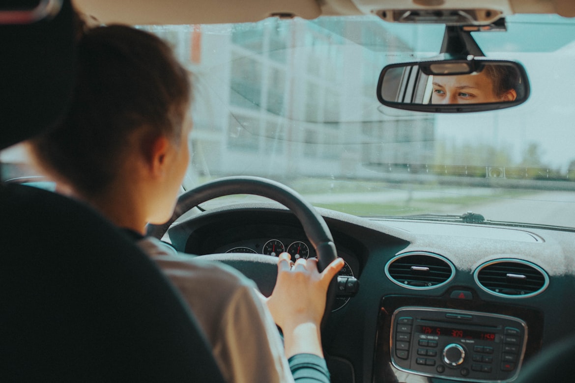 A picture taken from within a vehicle of a woman driving her car